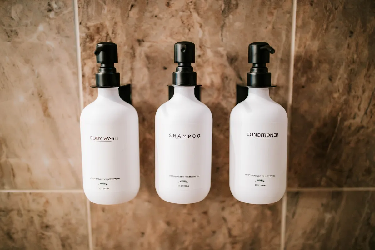 A bathroom scene with body wash, shampoo, and conditioner artfully arranged, suggesting a modern and refreshing space for personal care and relaxation.